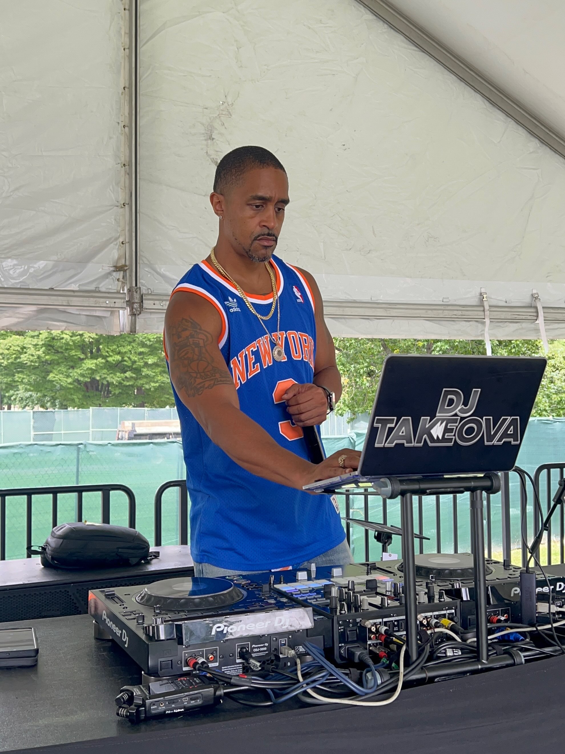 DJ Takeova working the Pioneer decks under the Queens College stage tent