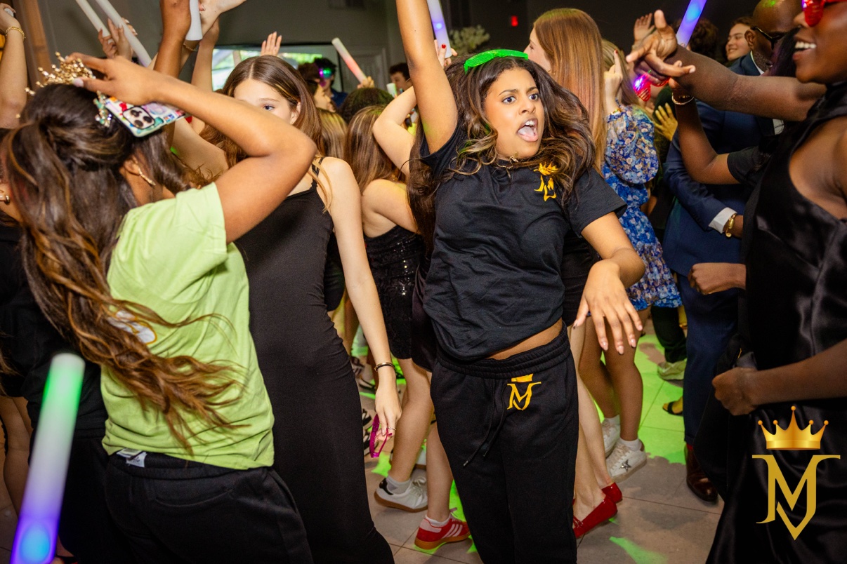 Young guests dancing with light-up foam sticks at a youth party